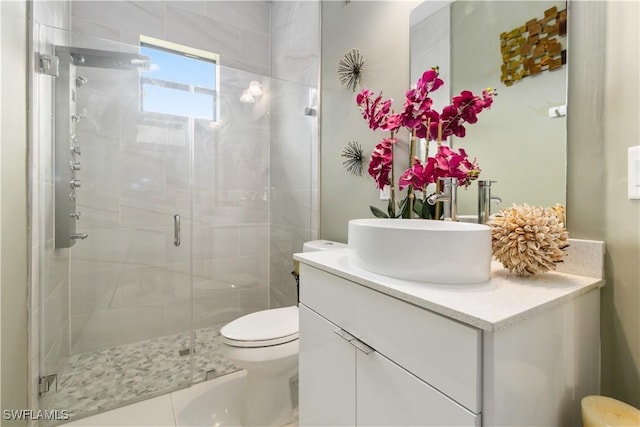 bathroom with toilet, tile patterned flooring, a shower with door, and vanity