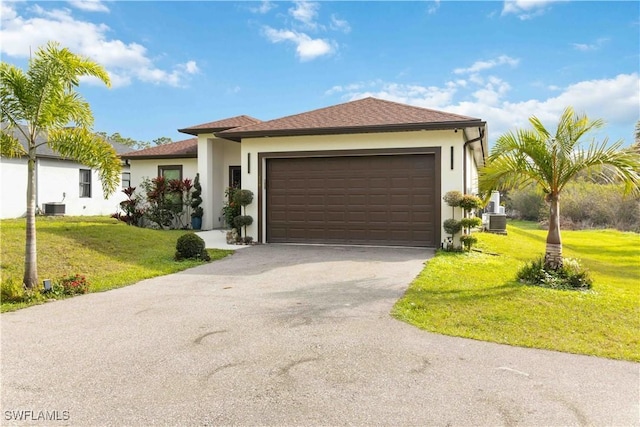 view of front facade featuring a garage, a front lawn, and central AC unit