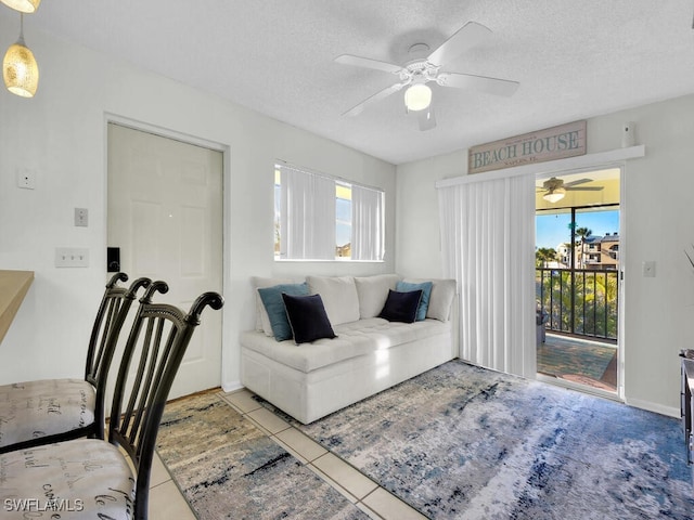 tiled living room featuring ceiling fan and a textured ceiling