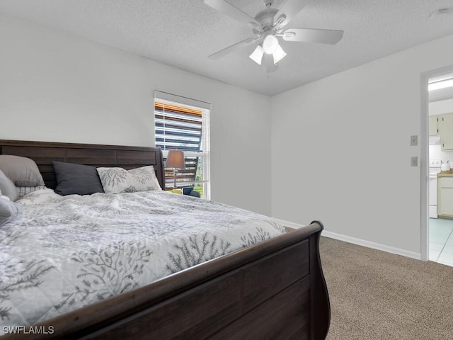 bedroom featuring ceiling fan, light colored carpet, and a textured ceiling