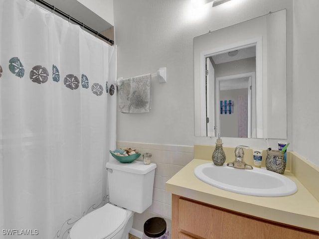 bathroom with vanity, tile walls, and toilet