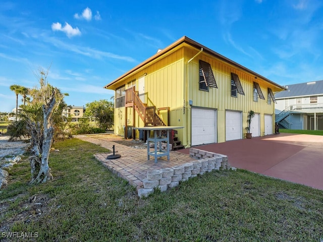 view of front of home featuring a garage, a patio area, and a front yard