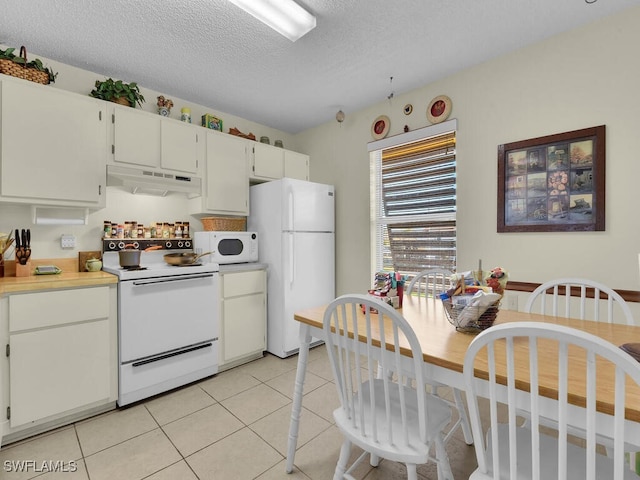 kitchen with white cabinetry, light tile patterned flooring, a textured ceiling, and white appliances