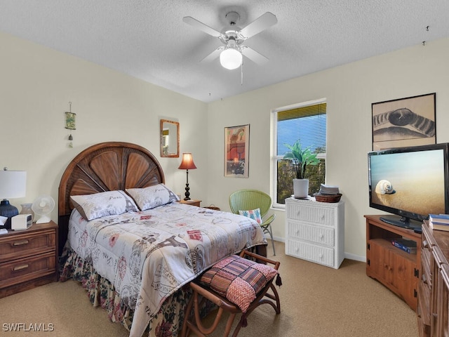 carpeted bedroom with ceiling fan and a textured ceiling