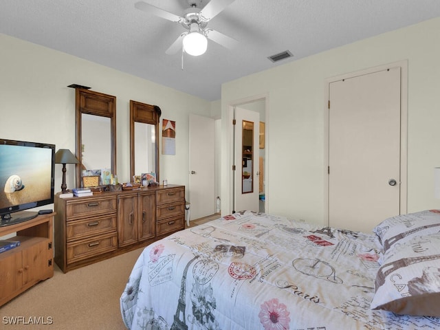 carpeted bedroom featuring ceiling fan and a textured ceiling