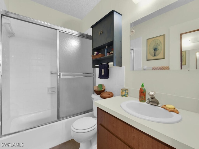 full bathroom with toilet, vanity, bath / shower combo with glass door, and a textured ceiling