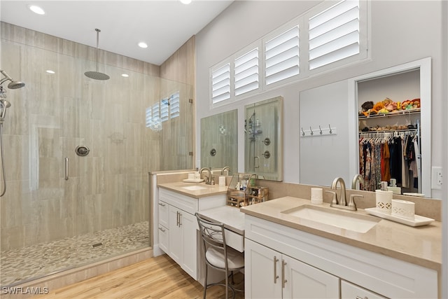 bathroom featuring hardwood / wood-style floors, vanity, and walk in shower