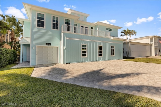 back of property featuring a yard, a balcony, and a garage