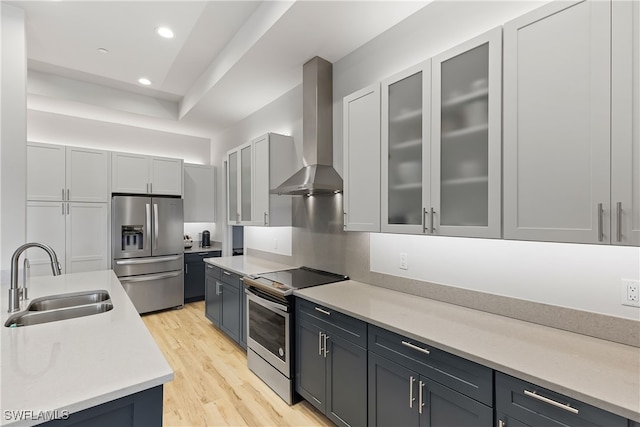 3967 Skyway Dr Unit 14, Naples, FL 34112 - kitchen featuring stainless steel appliances, a sink, wall chimney exhaust hood, light countertops, and light wood-style flooring