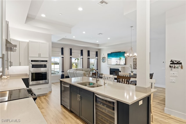 3967 Skyway Dr Unit 14, Naples, FL 34112 - kitchen featuring beverage cooler, open floor plan, a sink, a center island with sink, and light countertops
