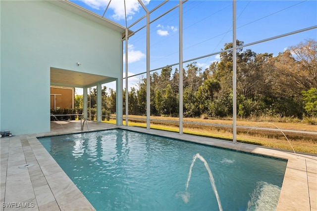 view of pool featuring glass enclosure, pool water feature, and a patio area