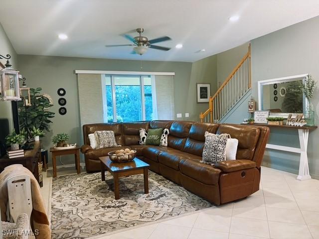 living room with ceiling fan and light tile patterned floors