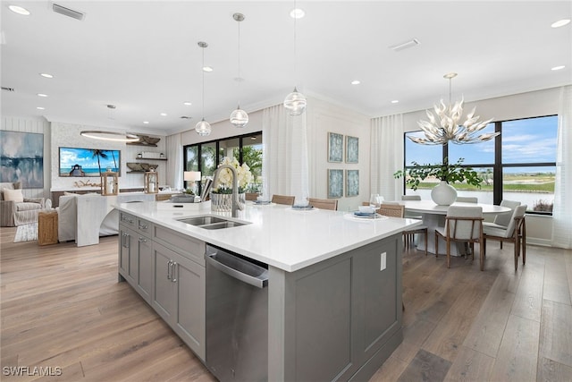 kitchen featuring dishwasher, gray cabinets, sink, and a kitchen island with sink