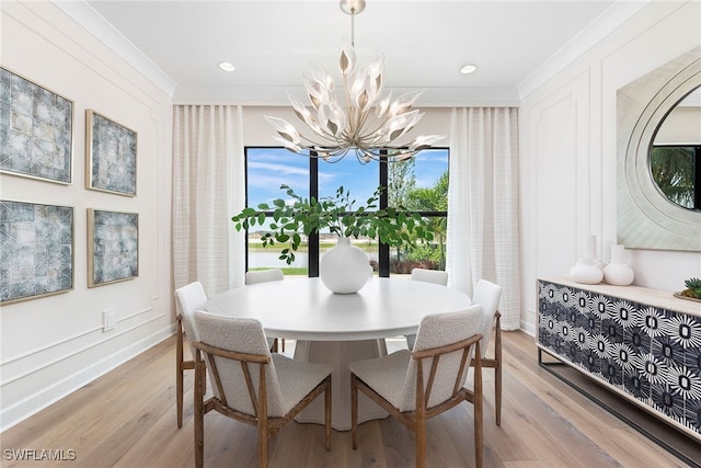 dining space featuring a chandelier, light wood-type flooring, and ornamental molding