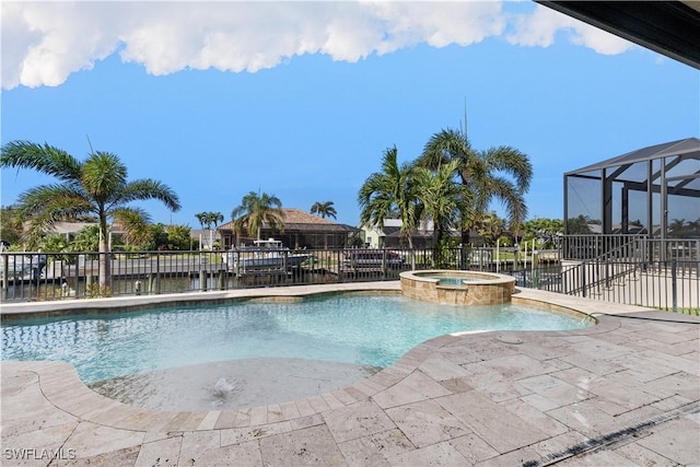 view of swimming pool with glass enclosure, an in ground hot tub, and a water view