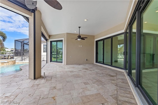 view of patio with glass enclosure, ceiling fan, and a pool with hot tub