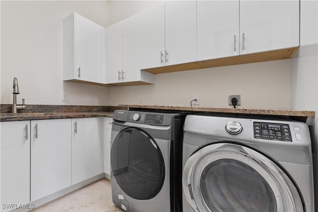 washroom featuring sink, light tile patterned floors, cabinets, and independent washer and dryer