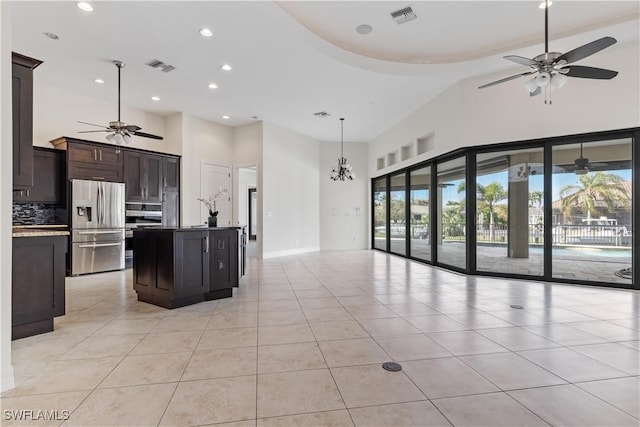 kitchen featuring a kitchen island with sink, stainless steel fridge with ice dispenser, pendant lighting, decorative backsplash, and light tile patterned floors