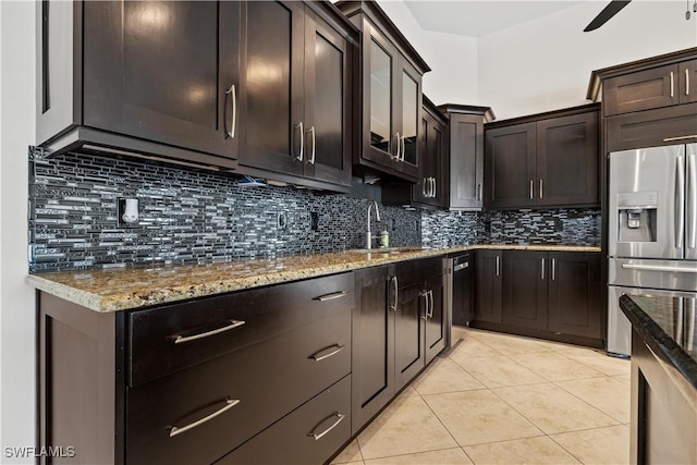 kitchen with decorative backsplash, stainless steel fridge, light tile patterned flooring, and sink