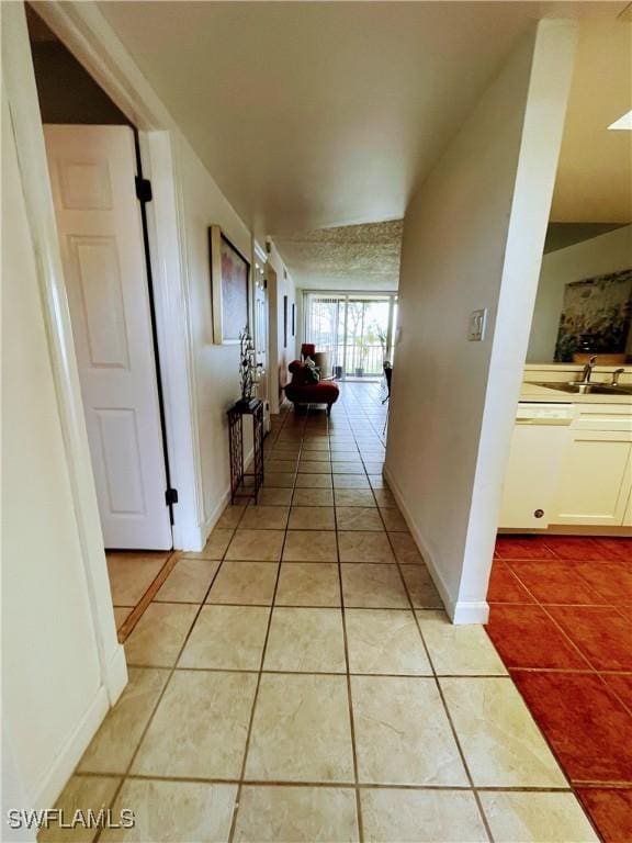 corridor featuring light tile patterned floors and sink