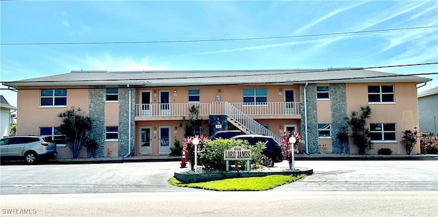 exterior space featuring stairway and stucco siding