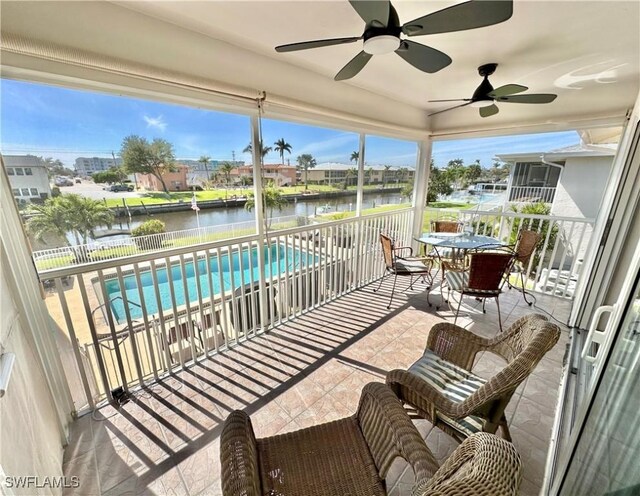 exterior space with a water view and a ceiling fan