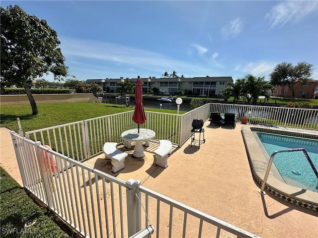 view of swimming pool with a lawn, fence, and a fenced in pool