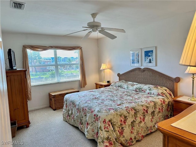 bedroom featuring ceiling fan, baseboards, visible vents, and light colored carpet