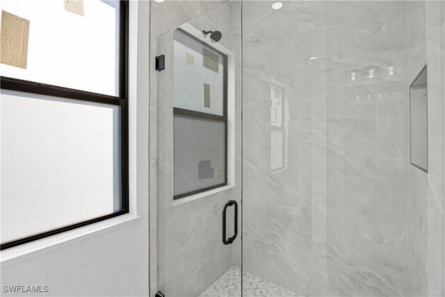 bathroom featuring a shower with door