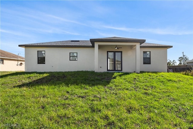 rear view of house featuring ceiling fan and a lawn