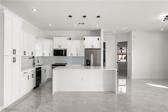 kitchen with white cabinetry, appliances with stainless steel finishes, a center island, pendant lighting, and sink