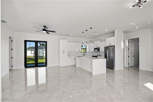 kitchen with stainless steel appliances, white cabinetry, hanging light fixtures, and a center island