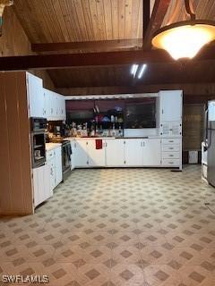 kitchen featuring white cabinets, range, wood ceiling, beamed ceiling, and oven