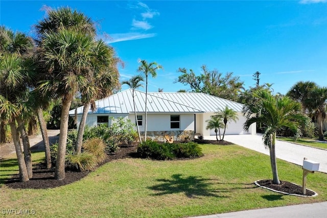 view of front of home featuring metal roof, a garage, concrete driveway, stucco siding, and a standing seam roof