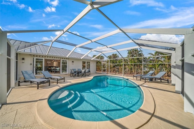 pool featuring glass enclosure and a patio