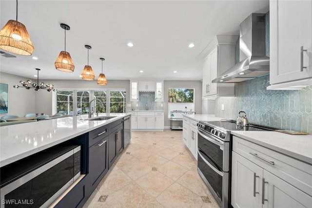 kitchen featuring stainless steel appliances, a healthy amount of sunlight, white cabinets, light countertops, and wall chimney exhaust hood