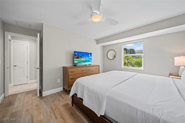 bedroom with light wood-type flooring, baseboards, and a ceiling fan