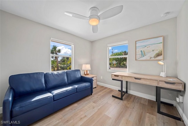 home office with ceiling fan, light wood finished floors, a wealth of natural light, and baseboards