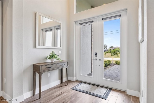 1142 SW 15th St, Cape Coral, FL 33991 - entryway featuring light wood-type flooring, french doors, and baseboards