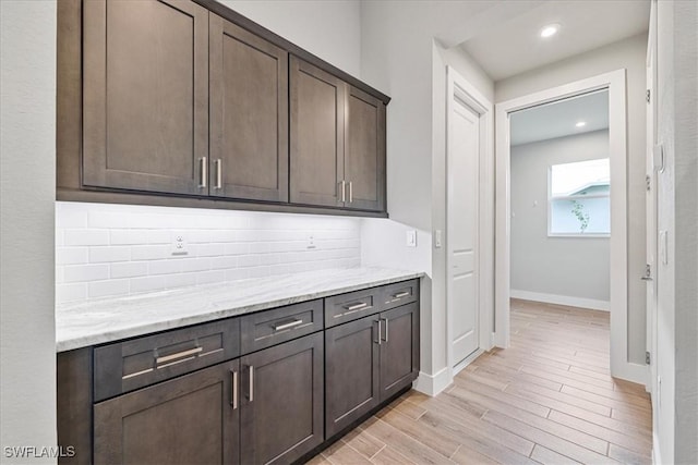 1142 SW 15th St, Cape Coral, FL 33991 - kitchen with dark brown cabinets, light wood-style flooring, baseboards, light stone counters, and recessed lighting