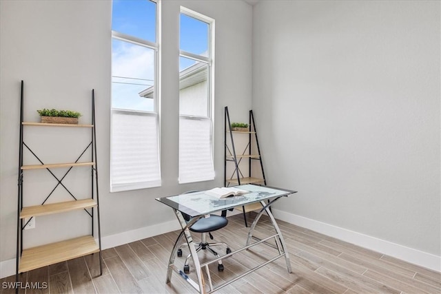 home office with light hardwood / wood-style flooring