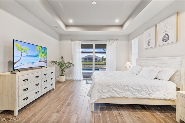 bedroom with a raised ceiling and access to outside