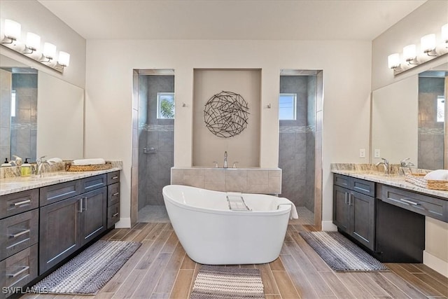 1142 SW 15th St, Cape Coral, FL 33991 - full bath featuring two vanities, a freestanding tub, walk in shower, and wood finish floors