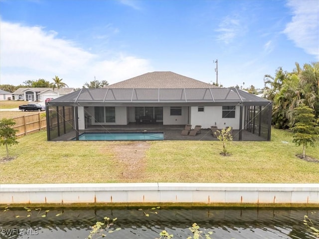 back of house featuring a lawn, a lanai, and a water view