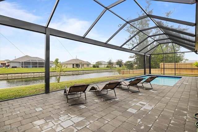 view of pool with a lanai, a patio area, a water view, and a yard