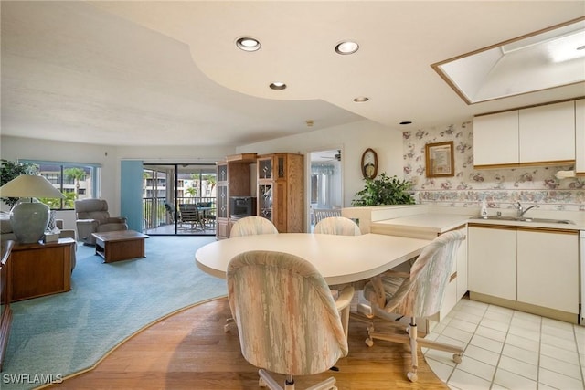 carpeted dining space with sink