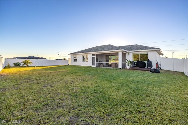 back of house with a yard and a sunroom