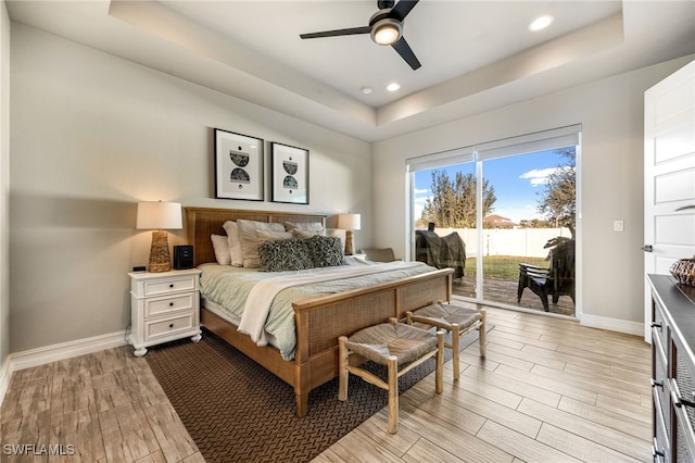 bedroom with ceiling fan, a raised ceiling, and access to outside