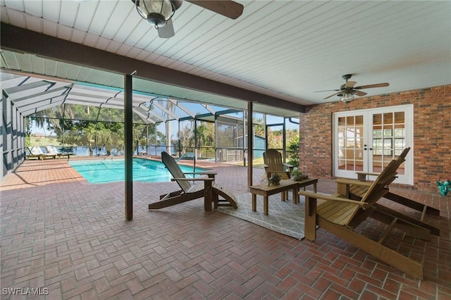 exterior space featuring glass enclosure, ceiling fan, a patio, and french doors