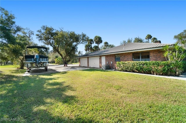 view of yard featuring central AC and a garage